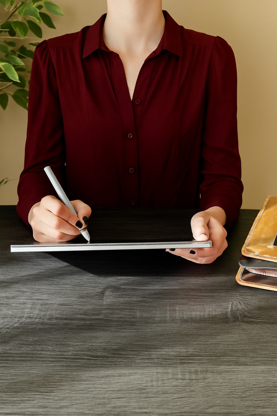 Woman using a sit-stand desk in a compact home workspace with minimalist accessories