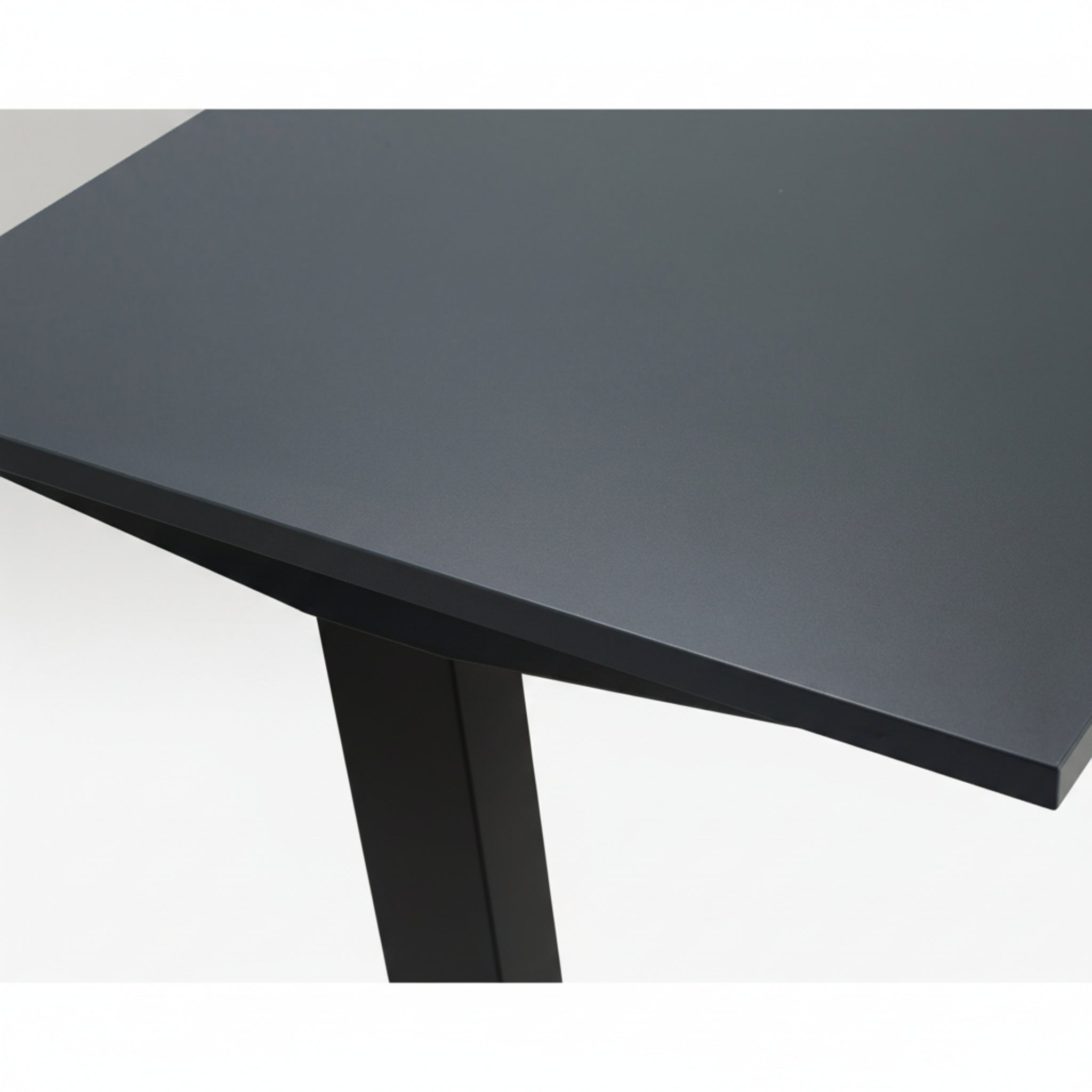 Close-up of Quiet Motor Standing Desk dark metal desktop and top of leg with black finish