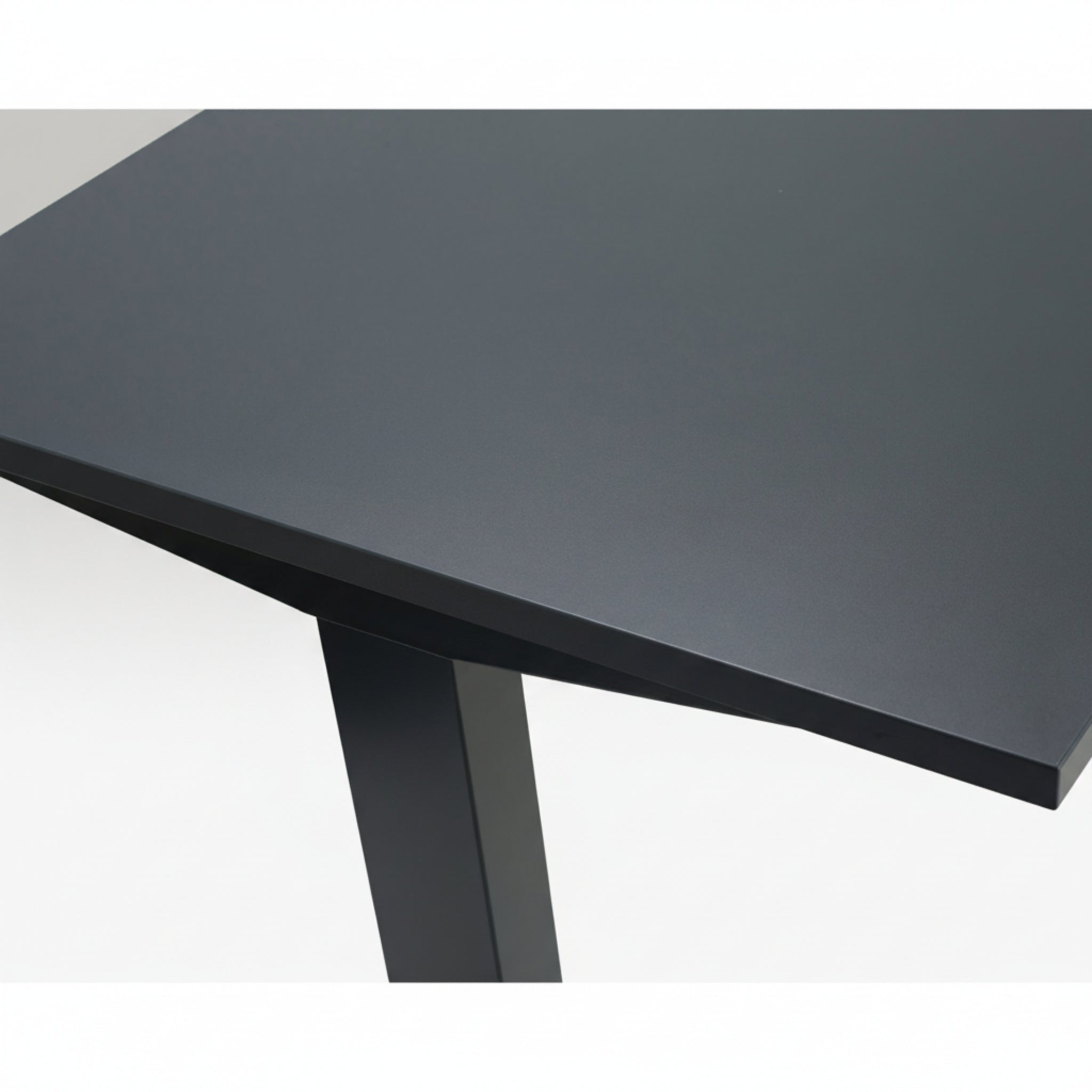 Close-up of Quiet Motor Standing Desk dark metal desktop and top of leg with dark grey finish