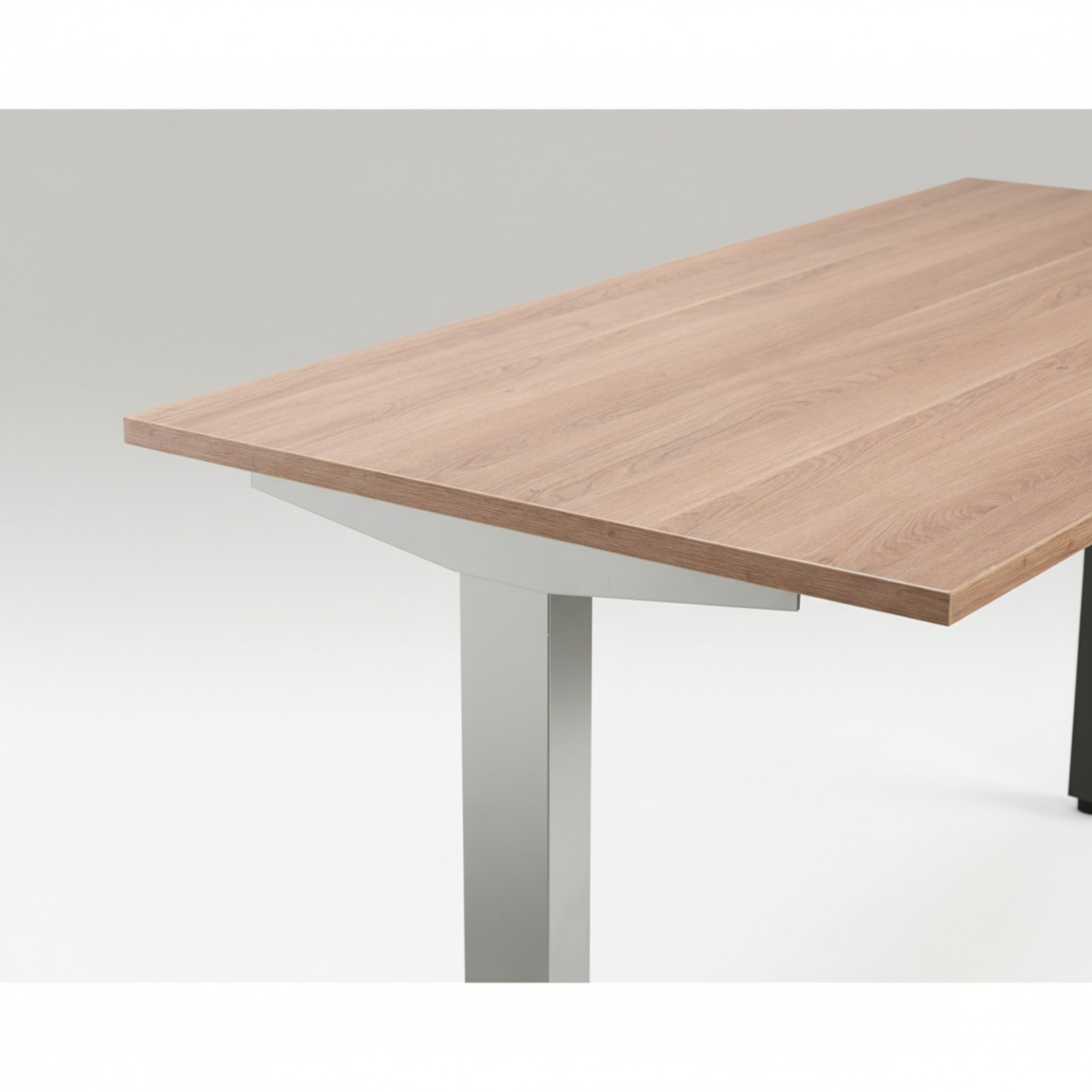 Close-up of Quiet Motor Standing Desk with wooden desktop and silver metal leg