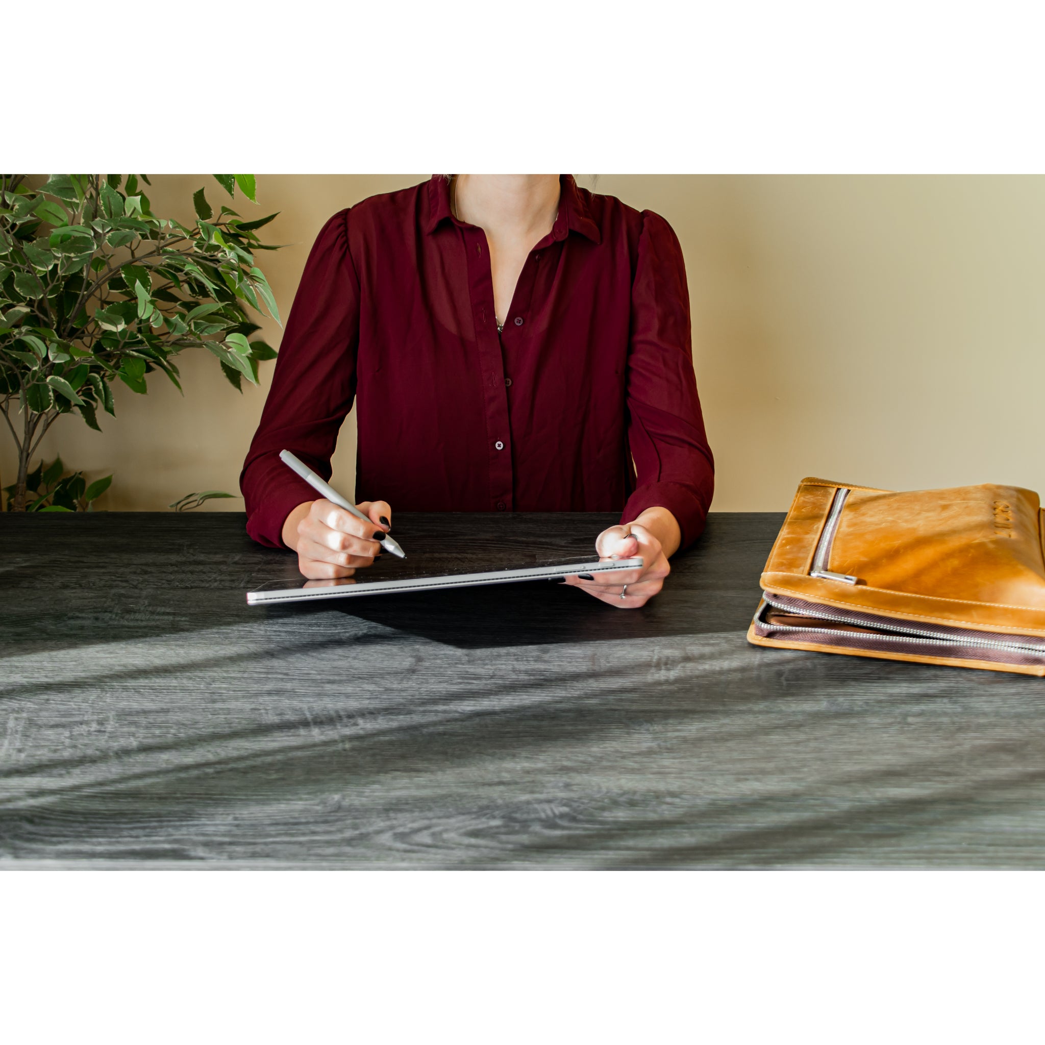 Woman using a sit-stand desk in a compact home workspace with minimalist accessories