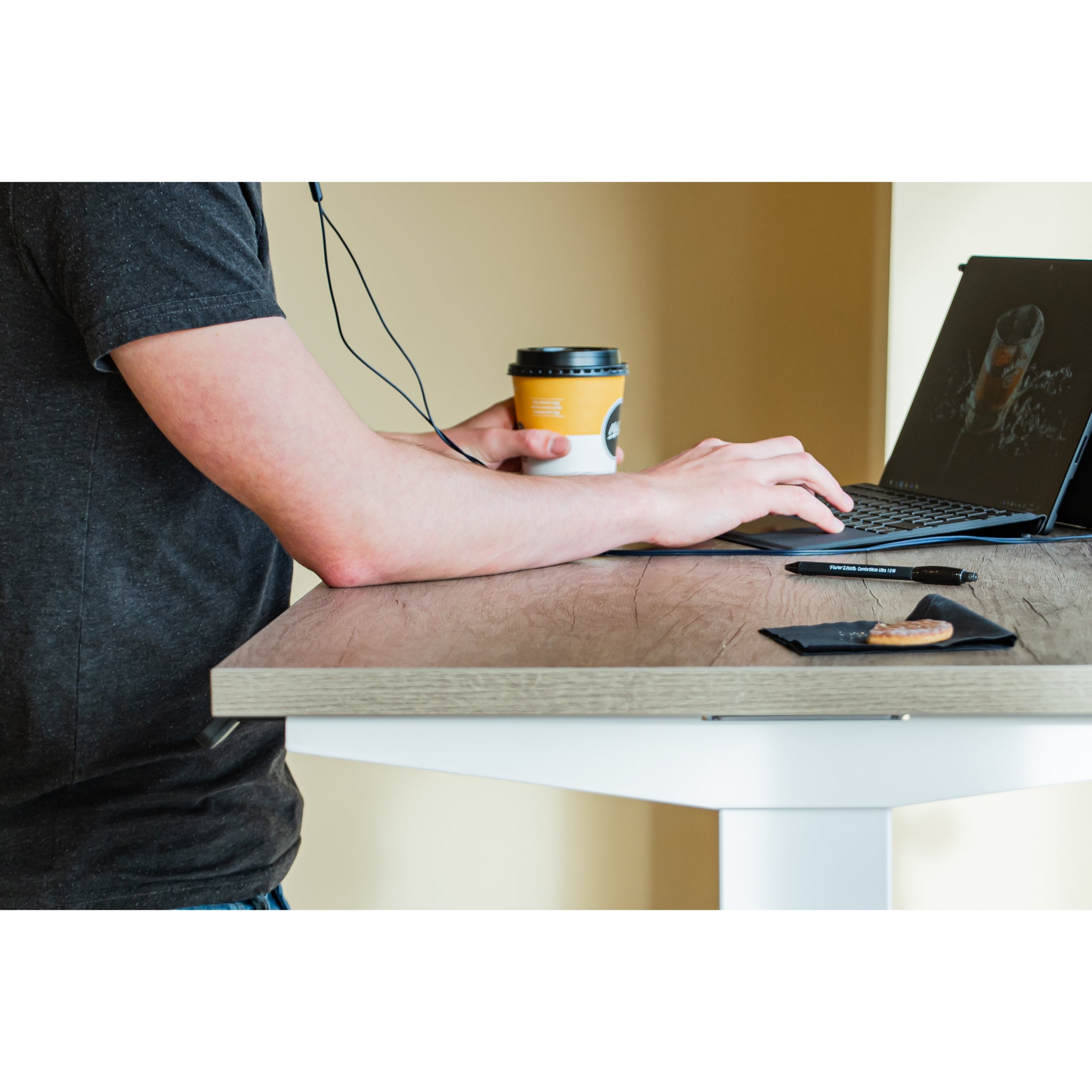 Person using desk controls on a compact standing desk