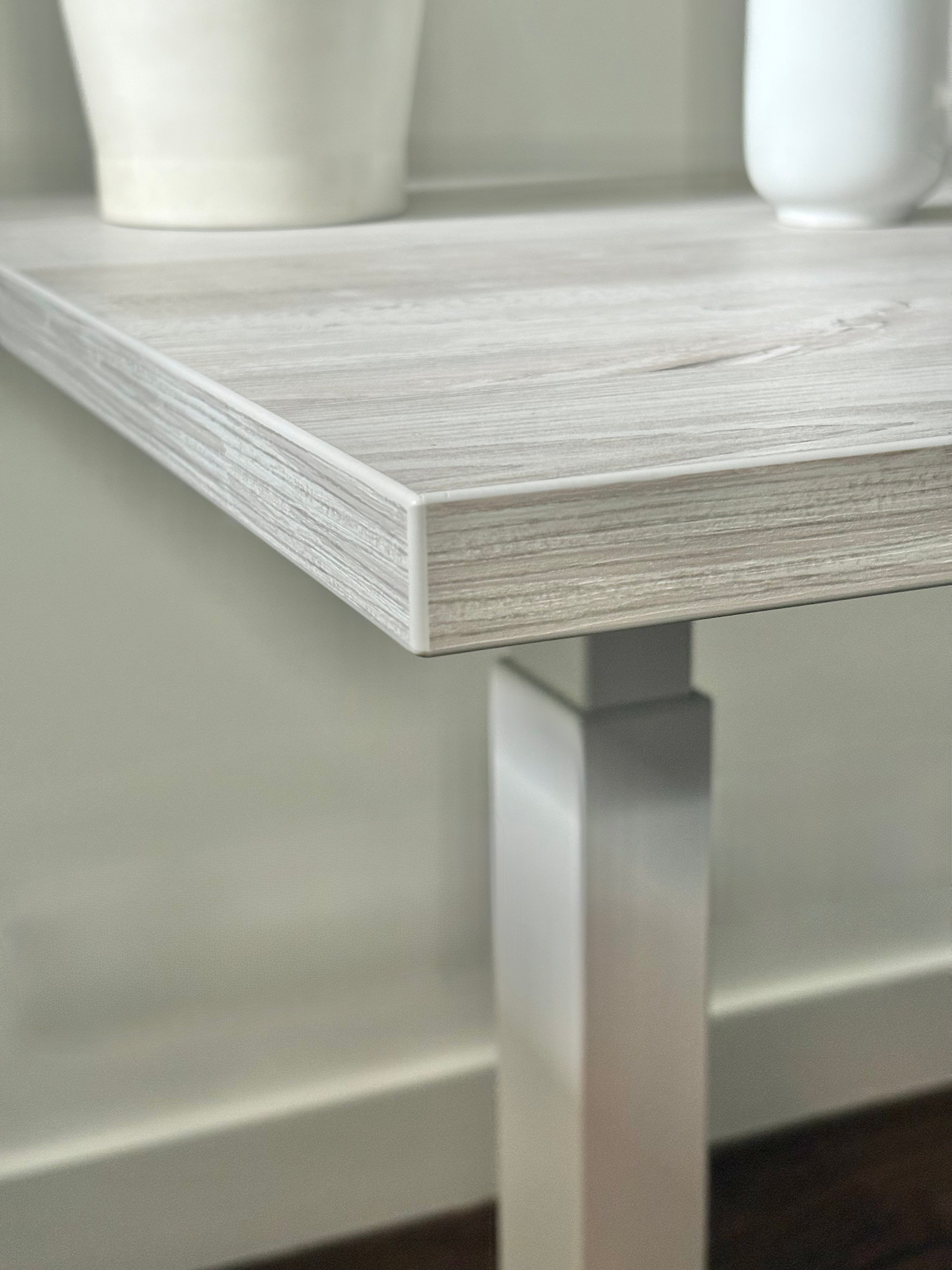 Close-up of the Casino Pine desktop finish on the UrbanErgo Core standing desk with white frame