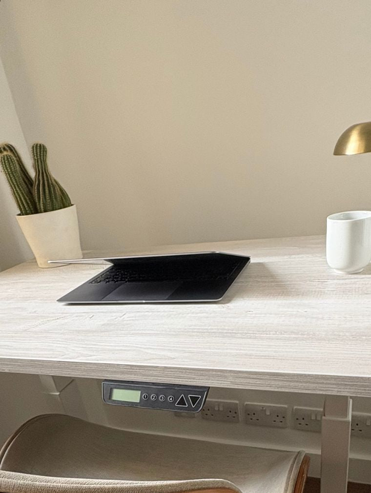 UrbanErgo Core electric standing desk with control panel shown in a small home office space